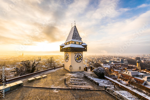 Sunrise at the Schloßberg landmark in Graz, Austria with the iconic clocktower and a dramatic sky