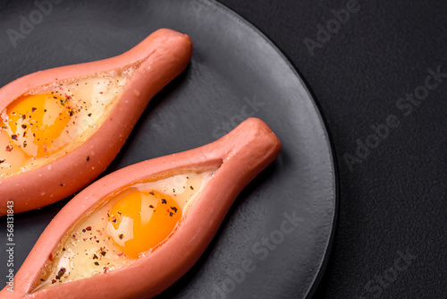 Composite concept of fried eggs inside a cut sausage with spices