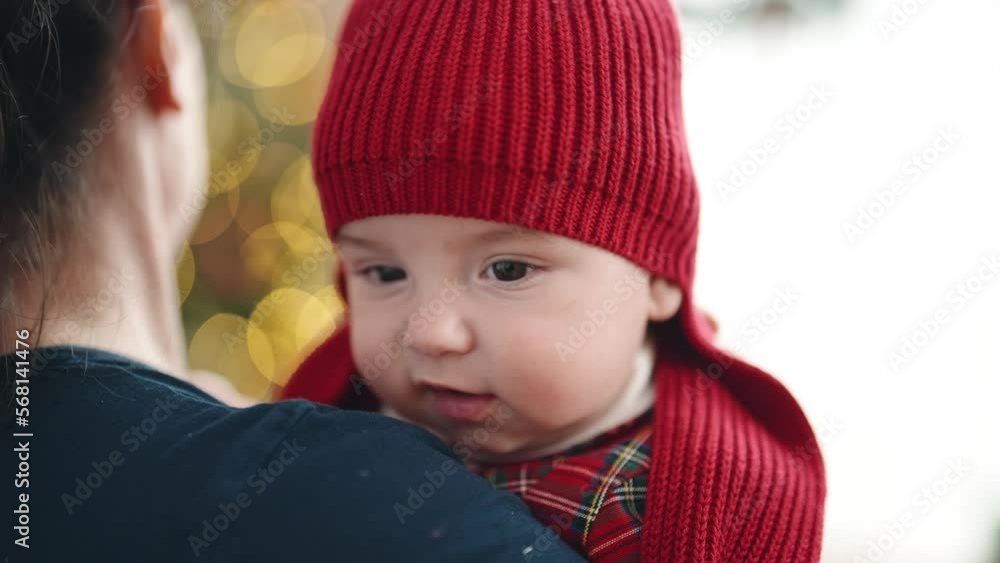 Adorable caucasian baby relaxed on mother arms at home Adorable caucasian baby relaxed on mother arms at home