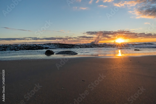 Waves from the Atlantic Ocean crash on the fossilized coral rocks of Singer Island Florida at sunrise
