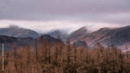 Lovely Winter sunrise landscape image of view from Walla Crag in Lake District towards distant mountains with low cloud