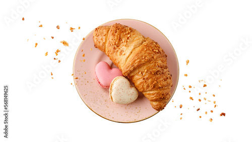 Fresh baked nut croissant and heart shape french cookies macarons macaroons with crumbs on vintage pink plate isolated on white background. photo