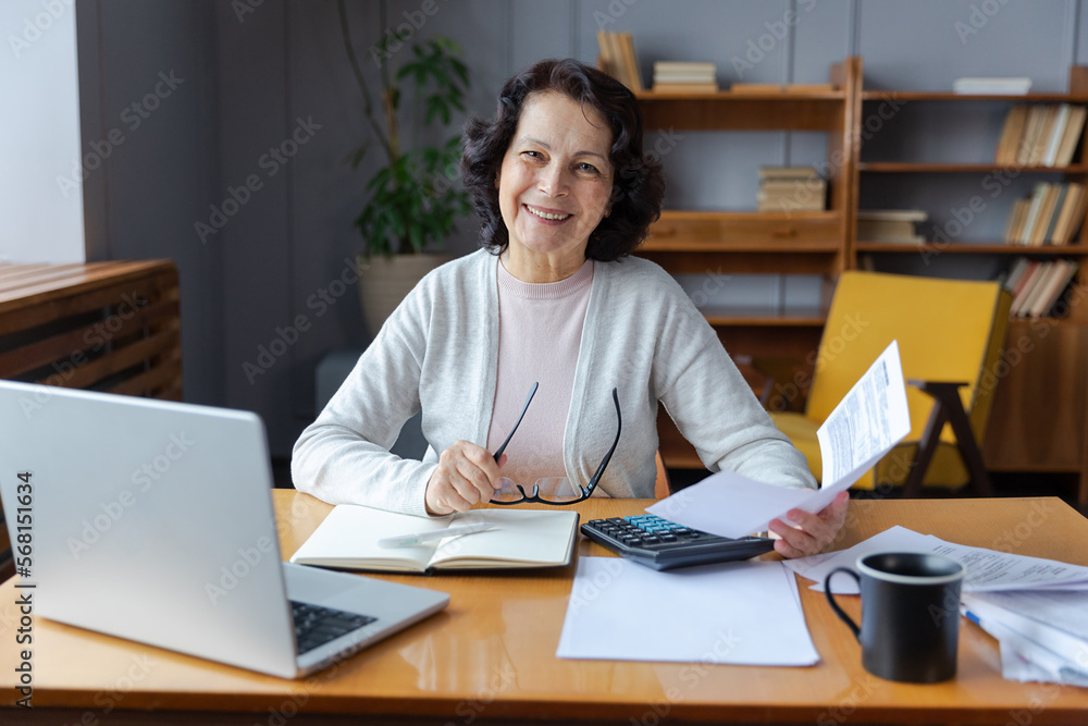custom made wallpaper toronto digitalMiddle aged senior woman sit with laptop and paper document, Smiling older mature lady reading paper bill pay online at home managing bank finances calculating taxes planning loan debt pension payment