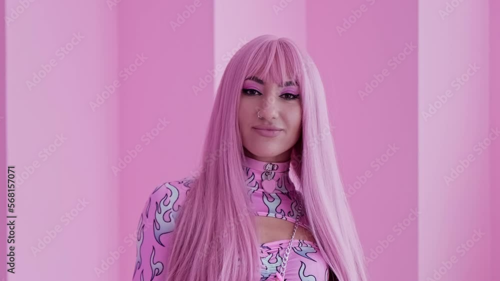 Glamour woman with pink hair and colorful lollipop candy looking at camera. Portrait of young sexy girl indoors. 30s elegant woman. Close-up in 4K, UHD Glamour woman with pink hair and colorful lollipop candy looking at camera. Portrait of young sexy girl indoors. 30s elegant woman. Close-up in 4K, UHD