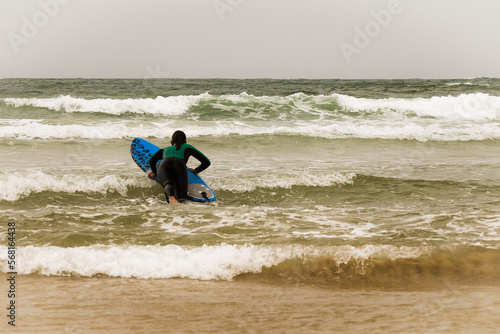 Female surfer on the beach entering the water