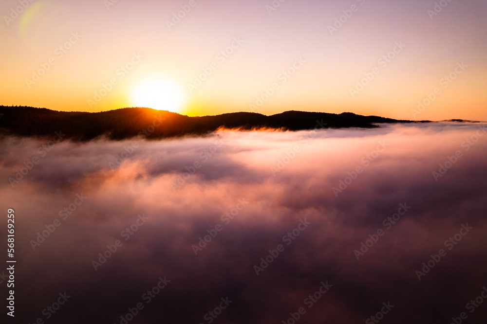 Aerial footage sunrise above clouds, fog bank, sea of clouds, beautiful serenity, peaceful morning sunrise.