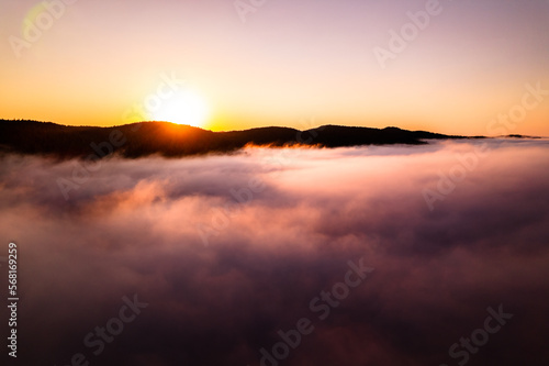 Aerial footage sunrise above clouds, fog bank, sea of clouds, beautiful serenity, peaceful morning sunrise.