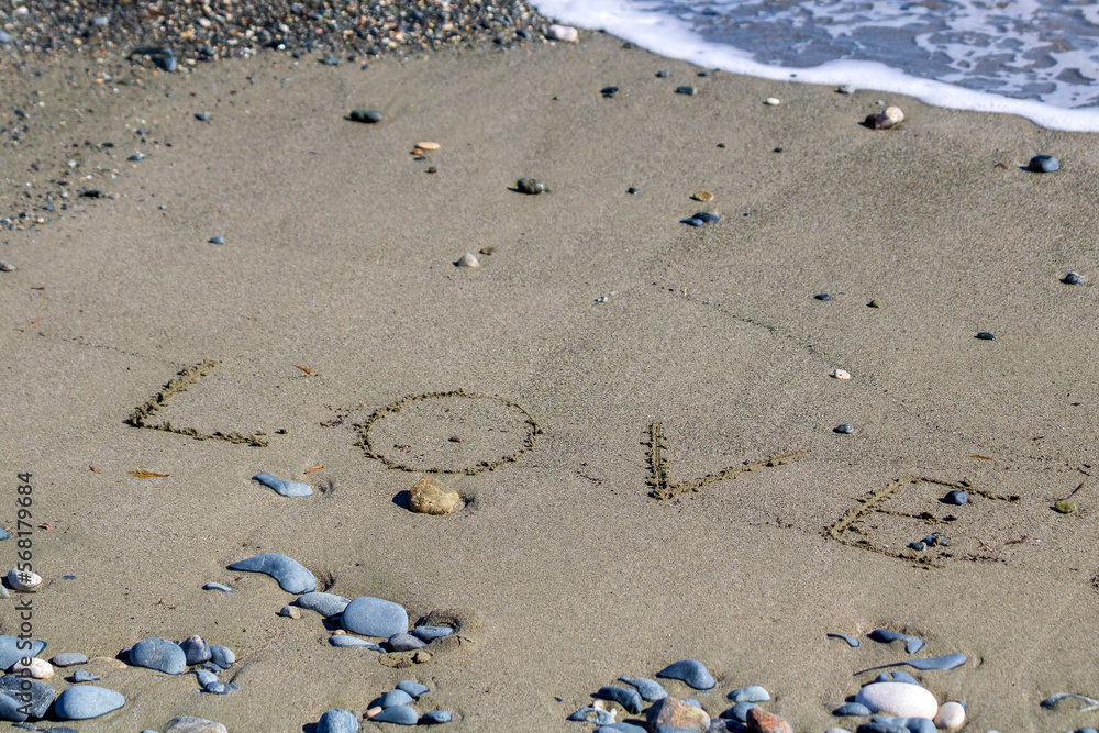 Word Love written on wet sand on sea beach Word Love written on wet sand on sea beach