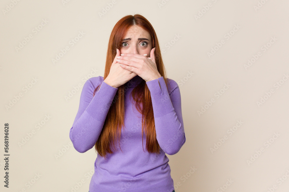 Young red hair woman isolated covering mouth with hands looking worried. Young red hair woman isolated covering mouth with hands looking worried.