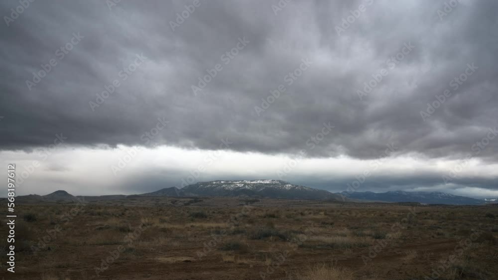 Stormy and gloomy dramatic timelapse over snow capped desert storm cloud mountain. Stormy and gloomy dramatic timelapse over snow capped desert storm cloud mountain.