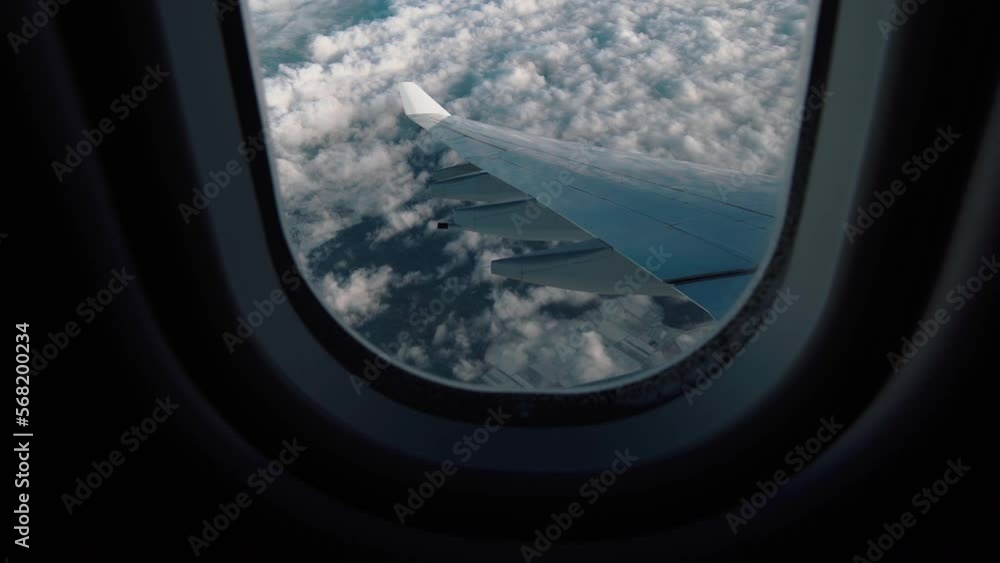 Airplane flight. Wing of an airplane flying above the clouds. Looking through window aircraft during flight in wing. Side view from a plane window of the aircraft wing and clouds. Travel and holidays Airplane flight. Wing of an airplane flying above the clouds. Looking through window aircraft during flight in wing. Side view from a plane window of the aircraft wing and clouds. Travel and holidays