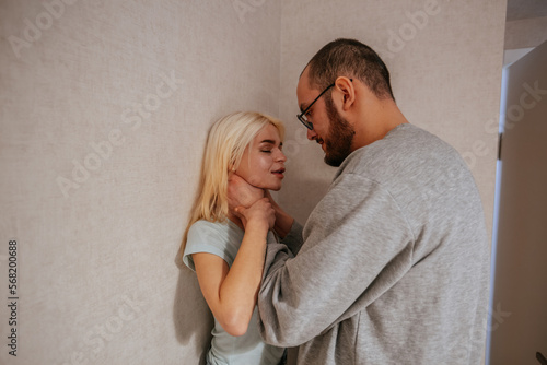 Angry man strangles a woman. Domestic violence concept photo