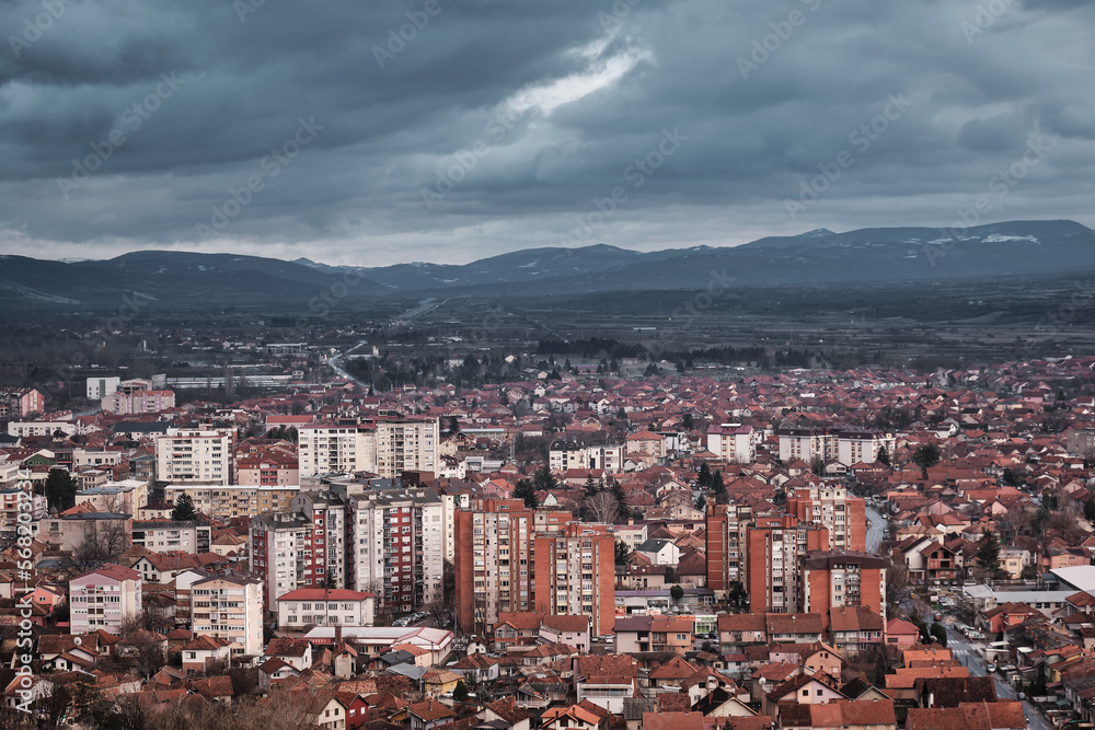 Dark, moody, cloudy sky on a winter day over cityscape with orange brick buildings