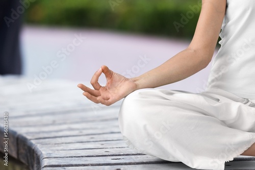 Young happy woman do yoga meditating on outdoor