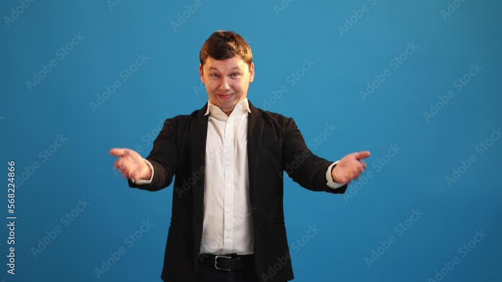 Smiling businessman waving hand asks come here, inviting to get good job tempting invite over blue studio background. Friendly man standing looking camera making invitation gesture and welcome sign Smiling businessman waving hand asks come here, inviting to get good job tempting invite over blue studio background. Friendly man standing looking camera making invitation gesture and welcome sign