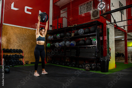 Wide horizontal shot of woman lifting a wall ball