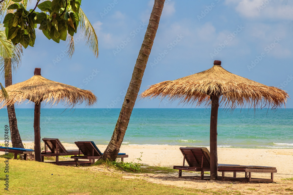 Wooden chairs and umbrellas on white sand beach