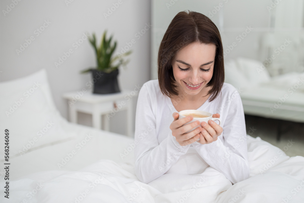 Joyful young lady enjoying fresh morning coffee at home Joyful young lady enjoying fresh morning coffee at home