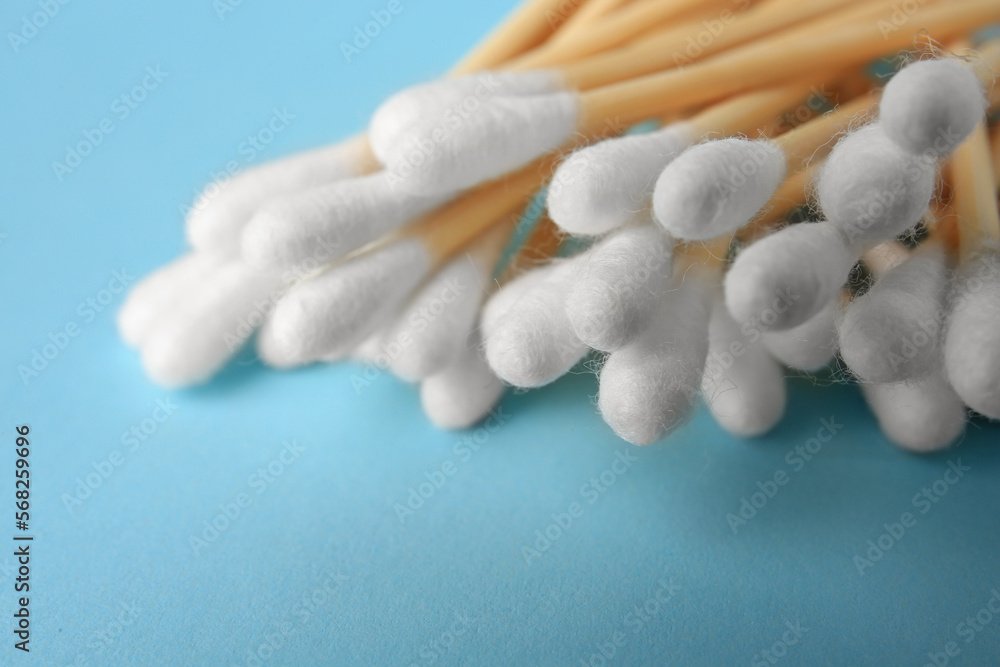 Heap of clean cotton buds on light blue background, closeup Heap of clean cotton buds on light blue background, closeup