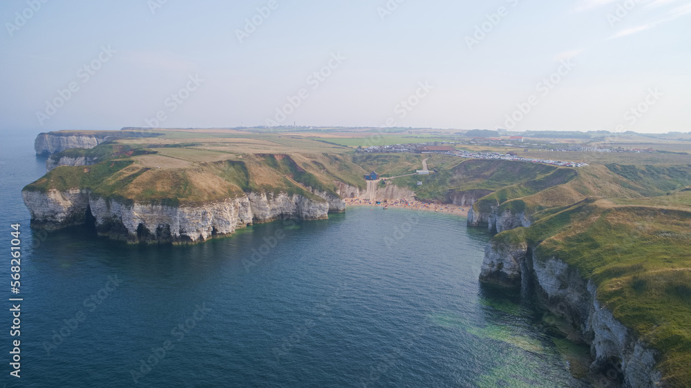 North Landing bay on the East Yorkshire coast of the United Kingdom showing the small beach and the craggy limestone chalk cliffs jutting out into the sea.