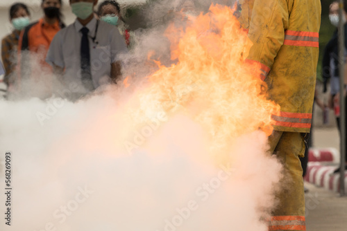 Showing how to use a fire extinguisher on a training fire for employees industry.Fire fighter concept.