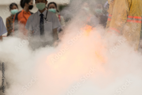Showing how to use a fire extinguisher on a training fire for employees industry.Fire fighter concept. © arcyto
