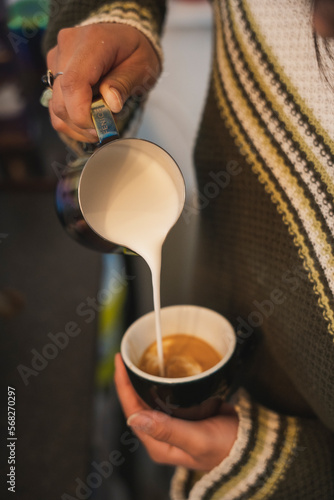 Barista sirviendo taza de café mediante el método de arte latte