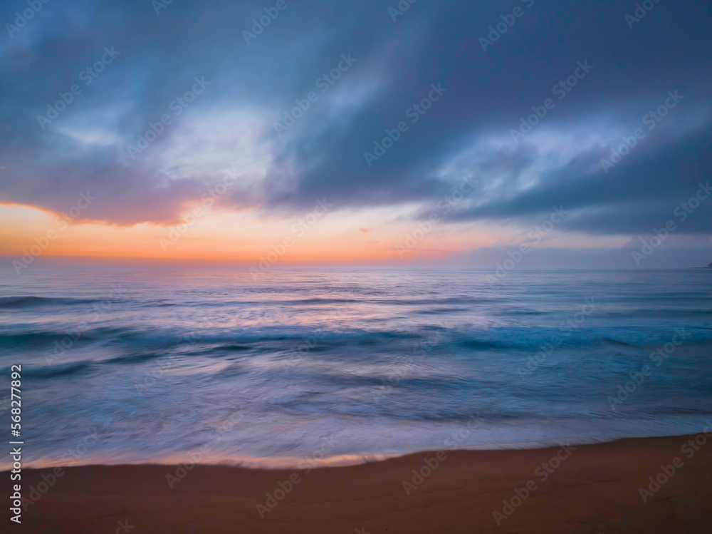 Obraz premium Summer sunrise at the seaside with clouds and haze