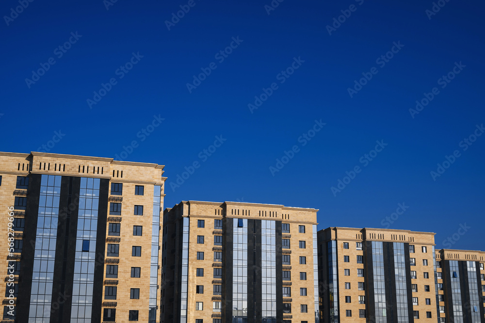 residential new luxury houses with windows and balconies on a blue sky background