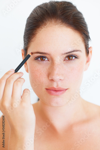 Makeup, beauty and portrait of woman with eyebrow pencil in studio for shape or grooming on white background. Face, brow and girl model with microblading tool for drawing, filling or product isolated