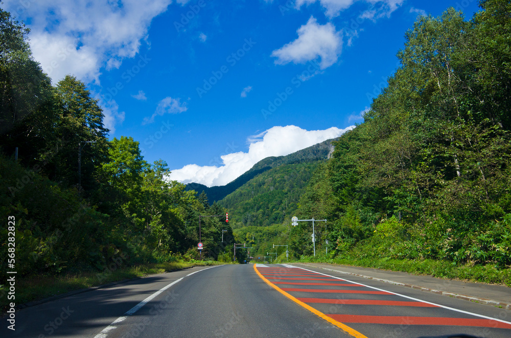 Rural Road at northern Kushiro city, the way leading through Lake Akan, Hokkaido, Japan.