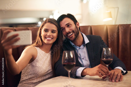 Selfie, wine and valentines day with a couple in a restaurant for a romantic fine dining celebration of love. Photograph, alcohol or anniversary with a man and woman celebrating a milestone together