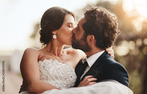 Love, wedding and kiss with a couple outdoor on their marriage day together for romance or tradition. Event, celebration or married with a birde and groom kissing outside after their ceremony