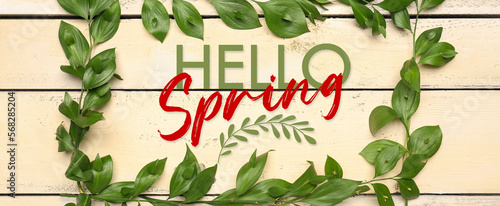 Banner with text HELLO, SPRING and green leaves on wooden background