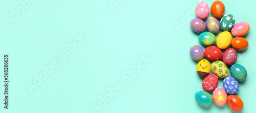 Many colorful Easter eggs on turquoise background with space for text
