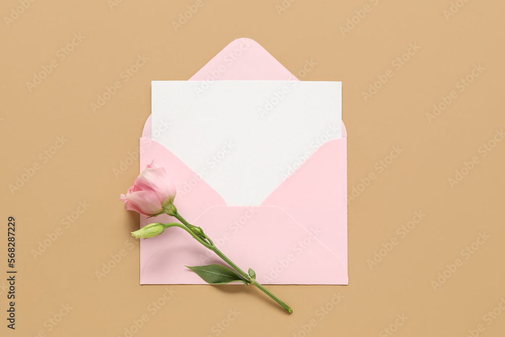 Envelope with blank card and eustoma flower on color background