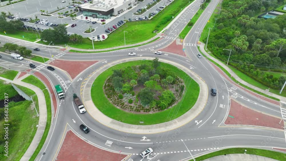 Aerial view of road roundabout intersection with fast moving heavy traffic. Urban circular transportation crossroads Aerial view of road roundabout intersection with fast moving heavy traffic. Urban circular transportation crossroads
