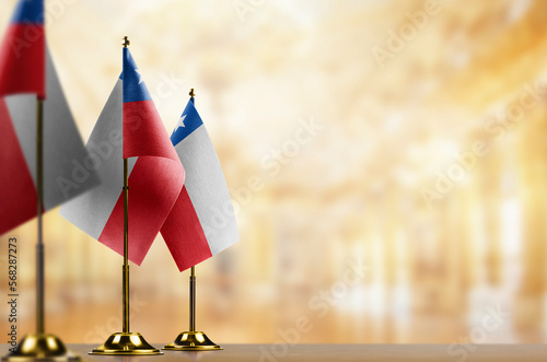 Small flags of the Chile on an abstract blurry background