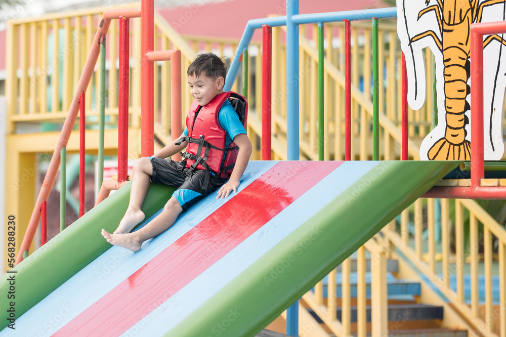 the boy playing slider in water park the boy playing slider in water park