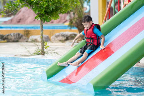 the boy playing slider in water park 