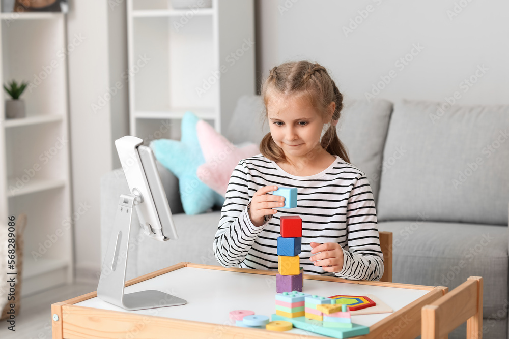 Little girl with cubes having online psychologist session at home Little girl with cubes having online psychologist session at home