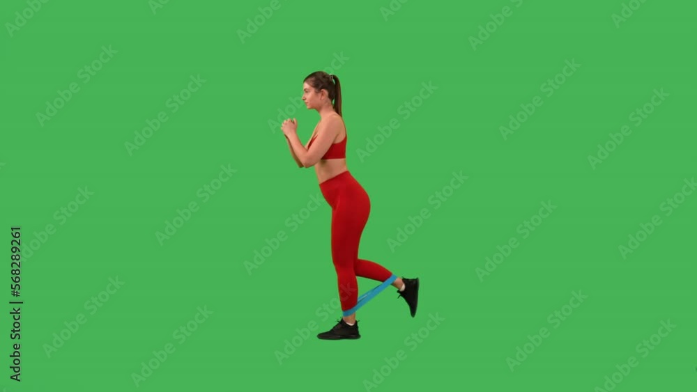active sporty woman kick foot behind with stretch band dressed red top and sports leggings Isolated on Green Screen studio active sporty woman kick foot behind with stretch band dressed red top and sports leggings Isolated on Green Screen studio