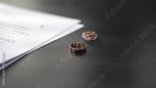 Divorce. The end of the relationship. Wedding rings fall on the table in the lawyer's office when signing divorce documents.