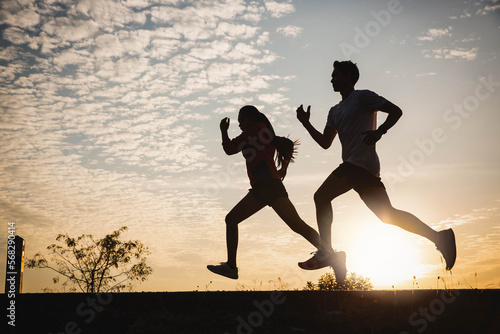 Young couple running on the road running for fitness, exercise, sports, people, exercise, running and lifestyle concept. Yong couple jogging and running outdoors in nature.