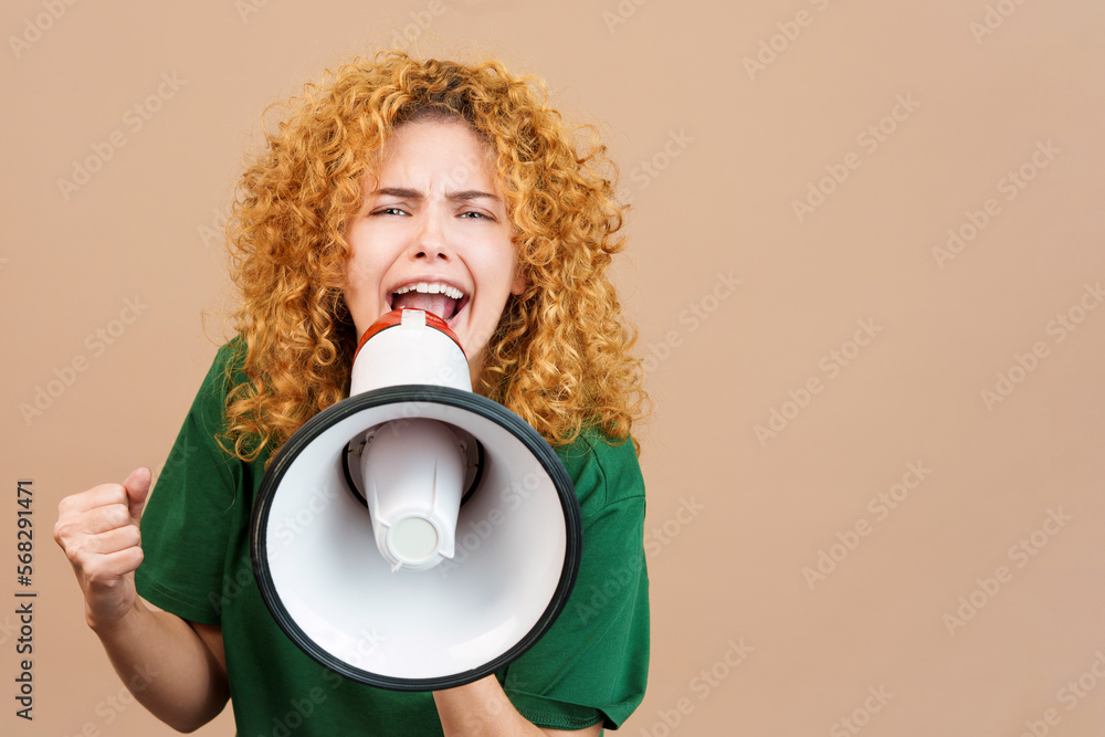 Woman looking at camera and shouting using a loudspeaker Woman looking at camera and shouting using a loudspeaker