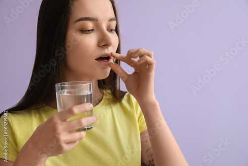 Young woman taking a vitami...