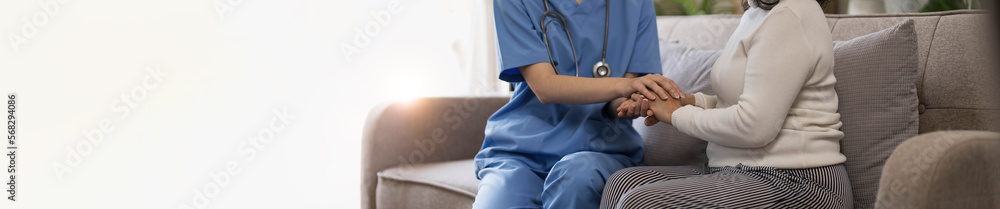 Happy patient is holding caregiver for a hand while spending time together. Elderly woman in nursing home and nurse. Happy patient is holding caregiver for a hand while spending time together. Elderly woman in nursing home and nurse.