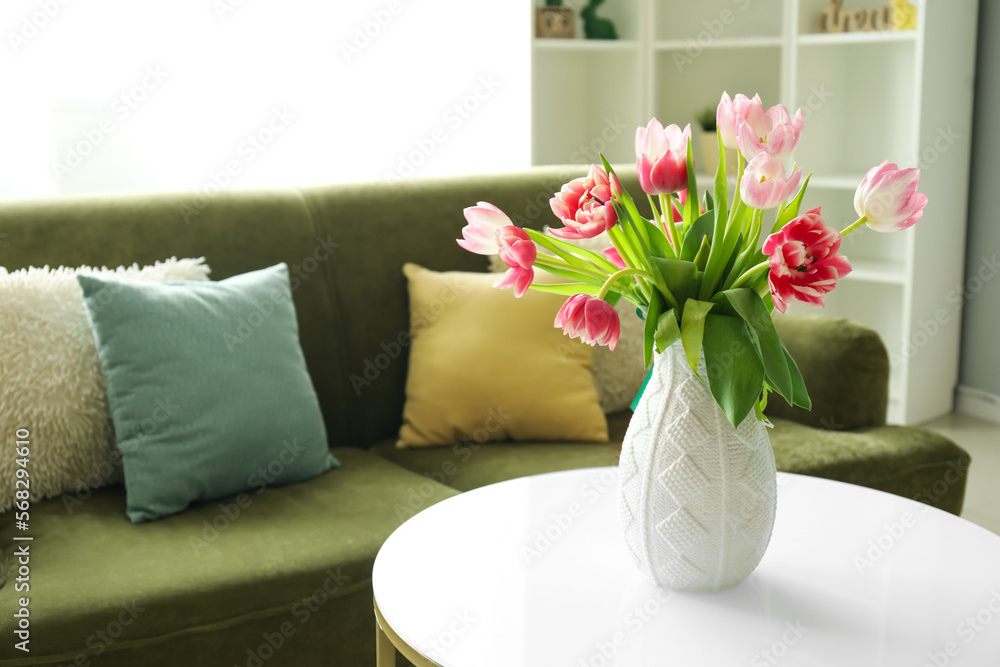 Naklejka premium Vase with pink tulips on table in modern living room, closeup