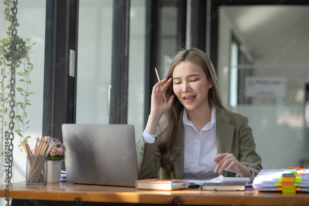 Happy excited young successful business woman and working online at the table in office, Asian business woman. Happy excited young successful business woman and working online at the table in office, Asian business woman.