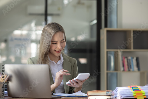 Happy excited young successful business woman and working online at the table in office, Asian business woman.